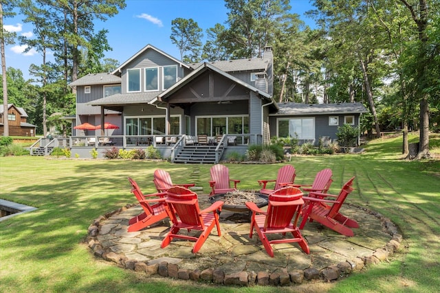 548 Winding Ln, Mount Vernon, TX 75457 - back of house with an outdoor fire pit, a chimney, a yard, and a sunroom