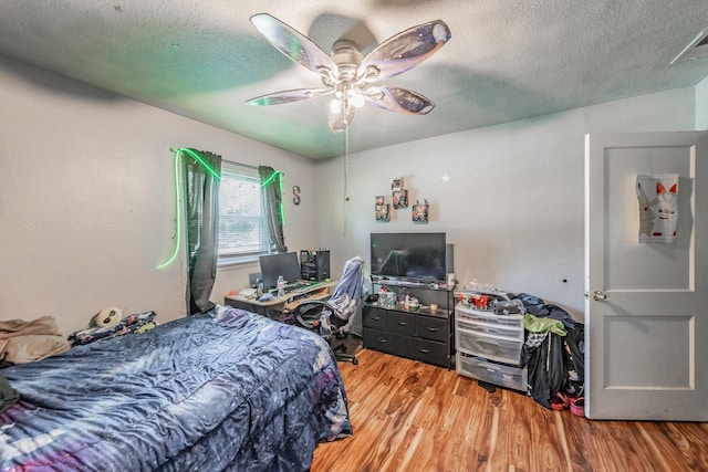 1106 Sunnyvale Dr, Arlington, TX 76010 - bedroom with wood finished floors, a textured ceiling, and a ceiling fan
