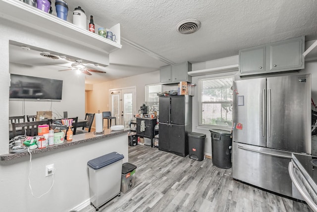 1106 Sunnyvale Dr, Arlington, TX 76010 - kitchen featuring stainless steel appliances, light wood-style flooring, ceiling fan, and a textured ceiling