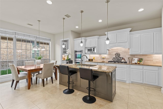 931 N Birdsong Dr, Allen, TX 75013 - kitchen with stainless steel appliances, decorative backsplash, a center island with sink, recessed lighting, and white cabinets