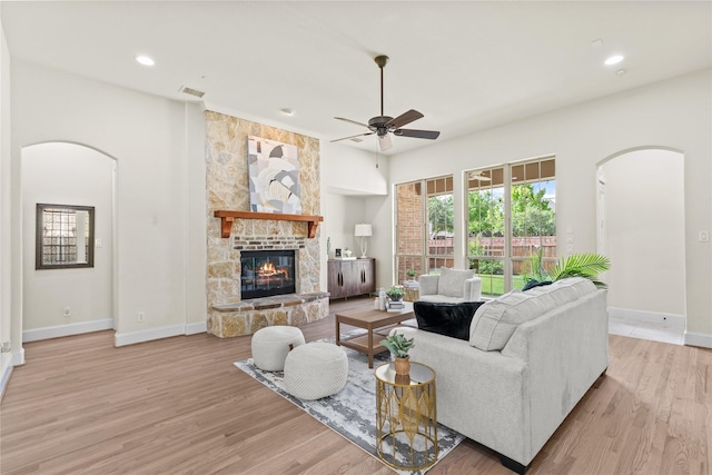 931 N Birdsong Dr, Allen, TX 75013 - living area with arched walkways, a ceiling fan, light wood-style floors, a fireplace, and recessed lighting