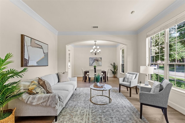 931 N Birdsong Dr, Allen, TX 75013 - living room with arched walkways, a chandelier, ornamental molding, and light wood-style flooring