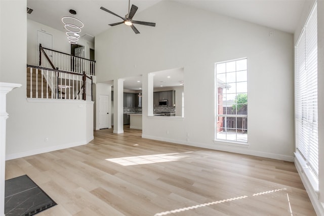 3214 Blair Oak Dr, Rowlett, TX 75089 - unfurnished living room featuring high vaulted ceiling, light wood finished floors, ceiling fan, and stairs