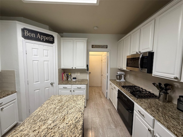 12763 Cardinal Creek Dr, Frisco, TX 75033 - kitchen with appliances with stainless steel finishes, white cabinetry, and light stone counters