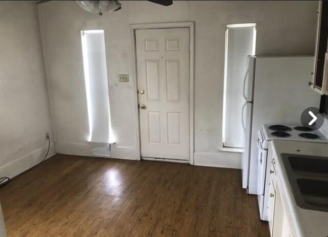 2207 N Elm St, Denton, TX 76201 - kitchen featuring dark wood-style flooring, white range with electric stovetop, light countertops, white cabinetry, and a ceiling fan