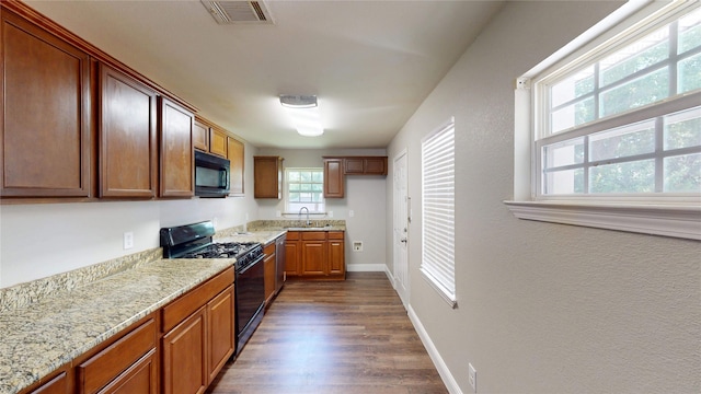 615 Royal Crest Dr, Mesquite, TX 75149 - kitchen with black appliances, dark wood-style floors, light stone counters, and brown cabinetry