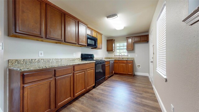 615 Royal Crest Dr, Mesquite, TX 75149 - kitchen featuring black appliances, dark wood finished floors, light stone counters, and brown cabinets