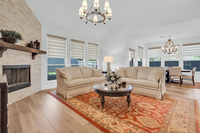 7432 Wispy Willow Ln, Little Elm, TX 76227 - living room with a chandelier, vaulted ceiling, plenty of natural light, wood finished floors, and a stone fireplace