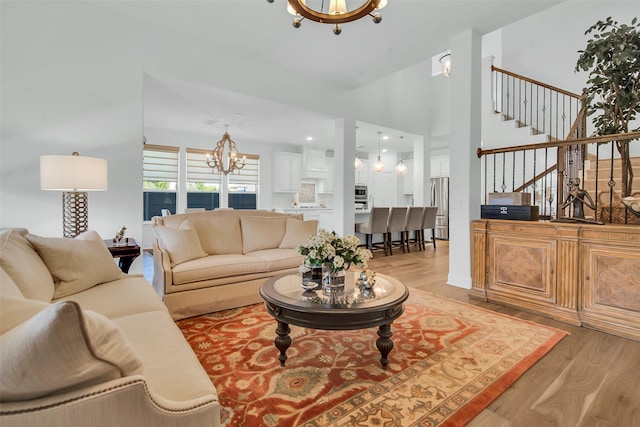 7432 Wispy Willow Ln, Little Elm, TX 76227 - living room with a chandelier, light wood finished floors, stairs, and a towering ceiling