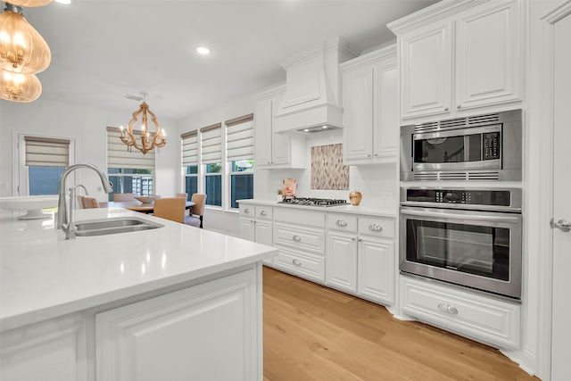 7432 Wispy Willow Ln, Little Elm, TX 76227 - kitchen with stainless steel appliances, a chandelier, custom range hood, recessed lighting, and light countertops