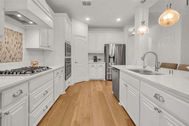 7432 Wispy Willow Ln, Little Elm, TX 76227 - kitchen featuring stainless steel appliances, custom range hood, white cabinetry, light countertops, and recessed lighting