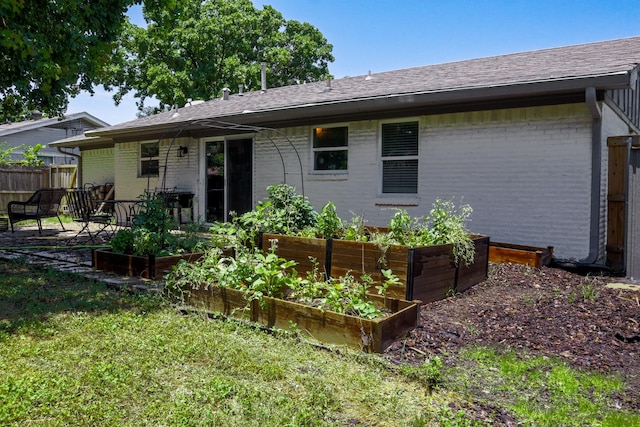 3323 Wise Dr, Mesquite, TX 75150 - rear view of house featuring a garden, brick siding, and a shingled roof