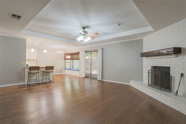 6306 Elmview Dr, Arlington, TX 76018 - unfurnished living room with a tray ceiling, a ceiling fan, a fireplace, dark wood-style floors, and a chandelier