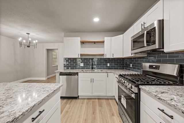 5120 Nadine Dr, Haltom City, TX 76117 - kitchen with appliances with stainless steel finishes, light wood-style floors, open shelves, tasteful backsplash, and recessed lighting