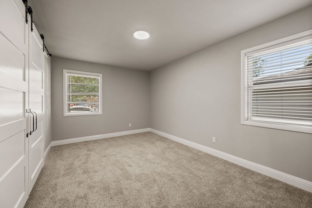5120 Nadine Dr, Haltom City, TX 76117 - spare room featuring light carpet and a barn door