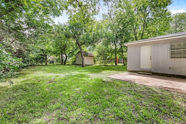 5120 Nadine Dr, Haltom City, TX 76117 - view of grassy yard featuring a storage shed, a patio area, and entry steps