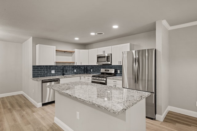 5120 Nadine Dr, Haltom City, TX 76117 - kitchen featuring appliances with stainless steel finishes, open shelves, light wood-style floors, white cabinetry, and backsplash