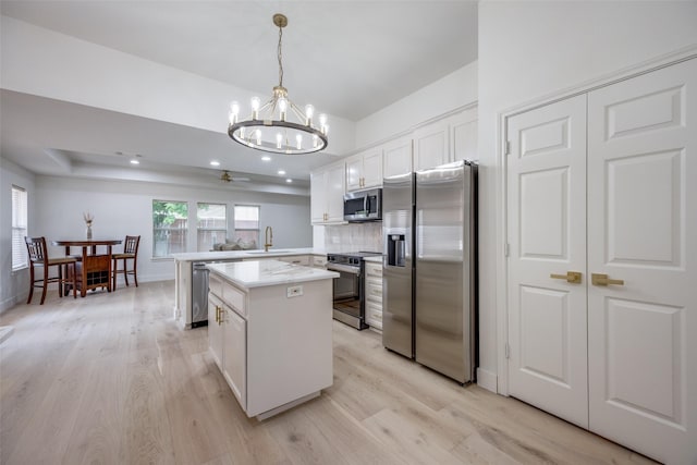 2308 Auburn Ct, Sherman, TX 75092 - kitchen with appliances with stainless steel finishes, light wood-style flooring, a chandelier, a kitchen island, and light countertops