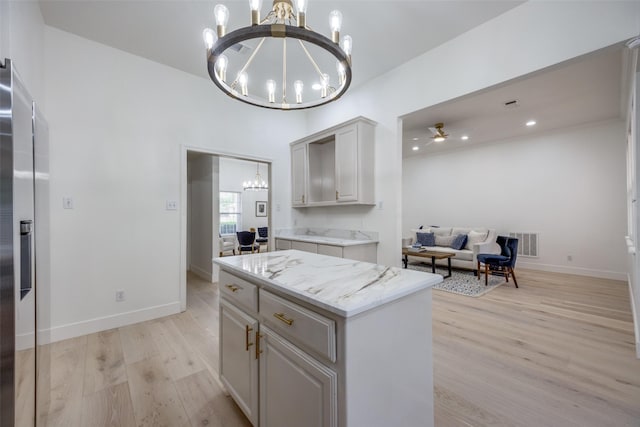 2308 Auburn Ct, Sherman, TX 75092 - kitchen featuring a chandelier, light wood-style floors, stainless steel fridge with ice dispenser, light stone countertops, and a center island