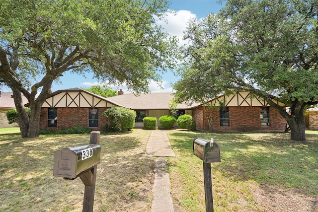 338 S Stewart Ave, Lancaster, TX 75146 - tudor-style house with a front yard and brick siding