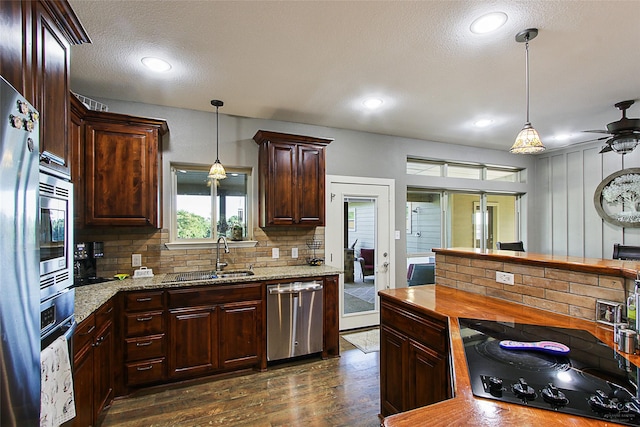 140 Stark Ln, Sherman, TX 75090 - kitchen with stainless steel appliances, dark wood finished floors, backsplash, a ceiling fan, and hanging light fixtures