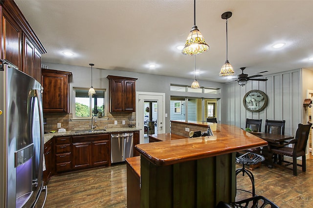 140 Stark Ln, Sherman, TX 75090 - kitchen featuring appliances with stainless steel finishes, dark wood-style floors, decorative backsplash, dark brown cabinets, and recessed lighting