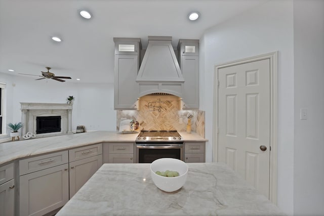 4418 Spring Garden Dr, Arlington, TX 76016 - kitchen featuring custom exhaust hood, stainless steel electric range oven, a fireplace, a ceiling fan, and light stone countertops