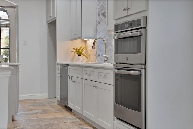 4418 Spring Garden Dr, Arlington, TX 76016 - kitchen featuring stainless steel appliances, decorative backsplash, light countertops, and white cabinetry