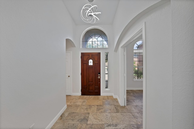 4418 Spring Garden Dr, Arlington, TX 76016 - entrance foyer with stone tile flooring, a towering ceiling, a chandelier, and arched walkways