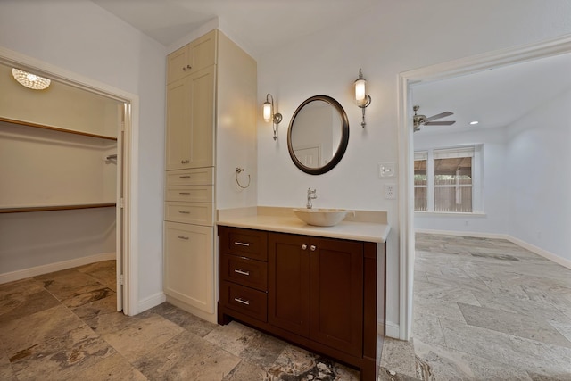 4418 Spring Garden Dr, Arlington, TX 76016 - bathroom featuring stone tile flooring, vanity, ceiling fan, and a walk in closet