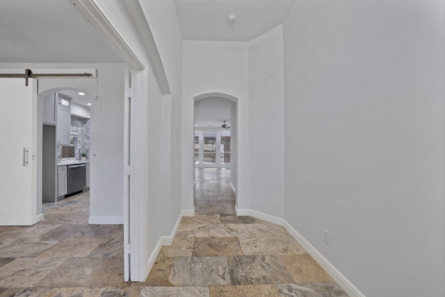 4418 Spring Garden Dr, Arlington, TX 76016 - corridor featuring stone tile flooring, a barn door, and arched walkways