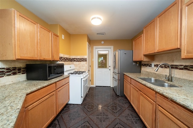 1825 E Shore Dr, Dallas, TX 75217 - kitchen with white range with gas stovetop, black microwave, tasteful backsplash, dark tile patterned floors, and light stone counters