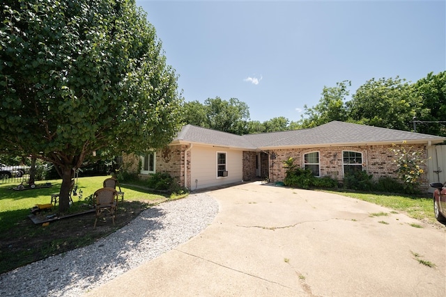 1825 E Shore Dr, Dallas, TX 75217 - view of front facade featuring concrete driveway, brick siding, a front lawn, and roof with shingles