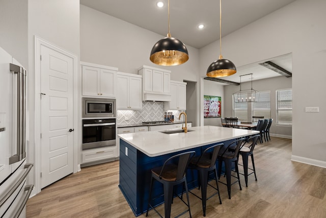 3000 Walker Way, Northlake, TX 76247 - kitchen featuring appliances with stainless steel finishes, tasteful backsplash, a kitchen breakfast bar, white cabinetry, and a towering ceiling