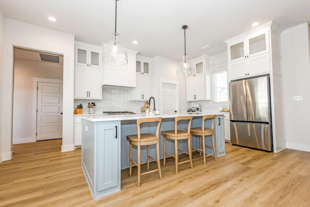 9209 Old Stoney Rd, Ponder, TX 76259 - kitchen with stainless steel appliances, backsplash, light countertops, light wood finished floors, and white cabinets