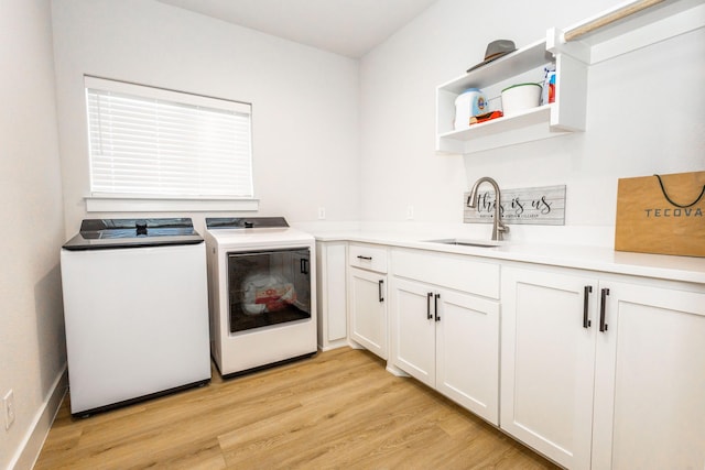 9209 Old Stoney Rd, Ponder, TX 76259 - laundry room featuring separate washer and dryer, cabinet space, and light wood-style flooring