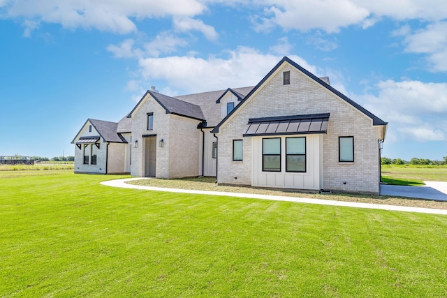 9209 Old Stoney Rd, Ponder, TX 76259 - view of front of property with board and batten siding, a front lawn, a standing seam roof, and brick siding