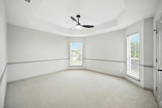901 Bluebird Ct, Burleson, TX 76028 - empty room with a ceiling fan, a raised ceiling, healthy amount of natural light, and carpet