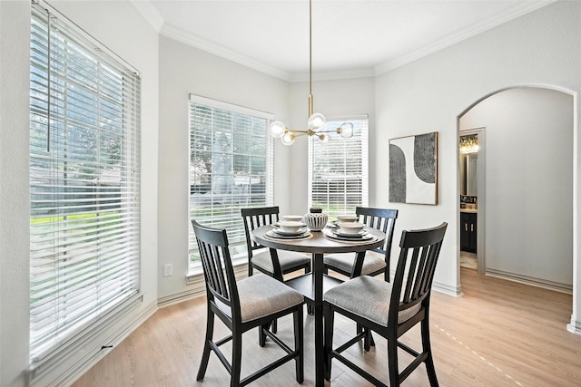 901 Bluebird Ct, Burleson, TX 76028 - dining room with light wood-style floors, ornamental molding, arched walkways, and a chandelier