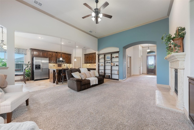 306 Spruce Trl, Forney, TX 75126 - living area featuring arched walkways, a ceiling fan, light colored carpet, crown molding, and high vaulted ceiling