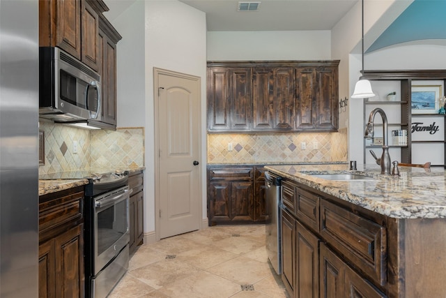 306 Spruce Trl, Forney, TX 75126 - kitchen with stainless steel appliances, light stone counters, dark brown cabinets, and tasteful backsplash