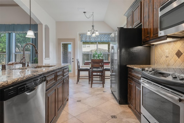 306 Spruce Trl, Forney, TX 75126 - kitchen featuring appliances with stainless steel finishes, healthy amount of natural light, tasteful backsplash, a chandelier, and vaulted ceiling