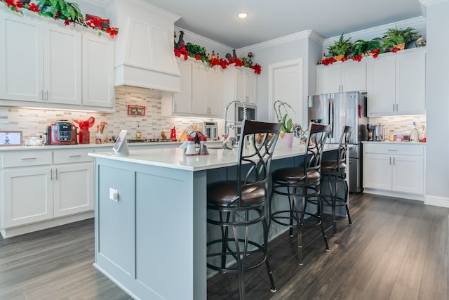 5616 Traveller Dr, North Richland Hills, TX 76180 - kitchen featuring custom exhaust hood, stainless steel fridge, tasteful backsplash, light countertops, and a kitchen island with sink