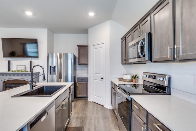 819 Twin Edge Dr, Royse City, TX 75189 - kitchen with stainless steel appliances, light countertops, wood finished floors, recessed lighting, and dark brown cabinets
