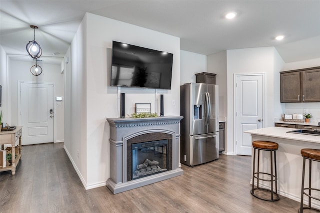 819 Twin Edge Dr, Royse City, TX 75189 - kitchen featuring stainless steel fridge with ice dispenser, dark brown cabinetry, a breakfast bar area, wood finished floors, and recessed lighting