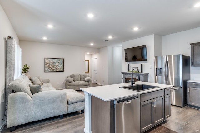 819 Twin Edge Dr, Royse City, TX 75189 - kitchen with stainless steel appliances, light wood-style floors, open floor plan, light countertops, and a center island with sink