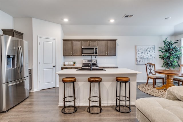 819 Twin Edge Dr, Royse City, TX 75189 - kitchen featuring appliances with stainless steel finishes, dark brown cabinetry, wood finished floors, light countertops, and recessed lighting