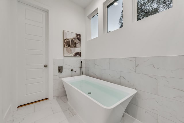 1403 Pueblo St, Dallas, TX 75212 - full bathroom with marble finish flooring, a soaking tub, tile walls, and wainscoting