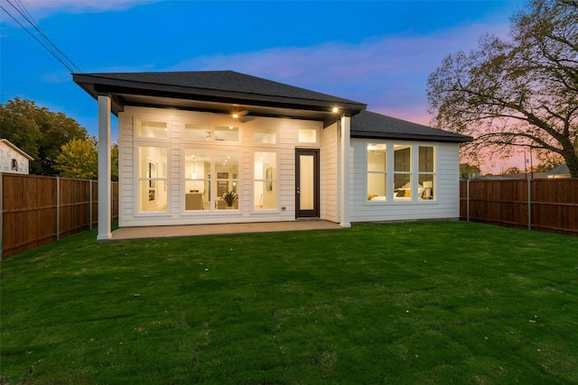 1403 Pueblo St, Dallas, TX 75212 - back of house at dusk with a fenced backyard, a patio area, and roof with shingles