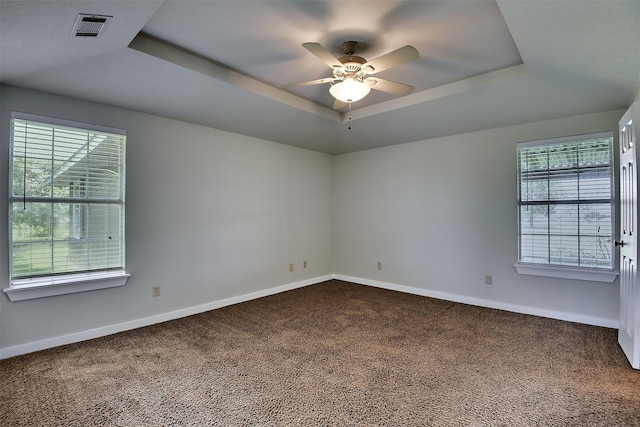 351 Marion Rd, Venus, TX 76084 - spare room featuring a tray ceiling, dark carpet, and a ceiling fan